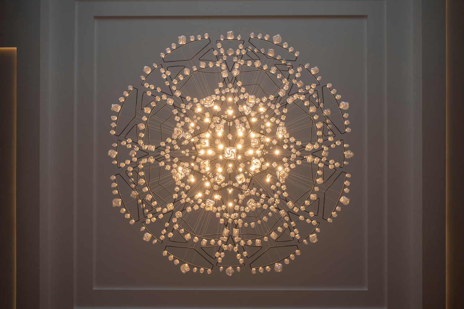SOLACE chandelier seen from directly below, radiating armature visible