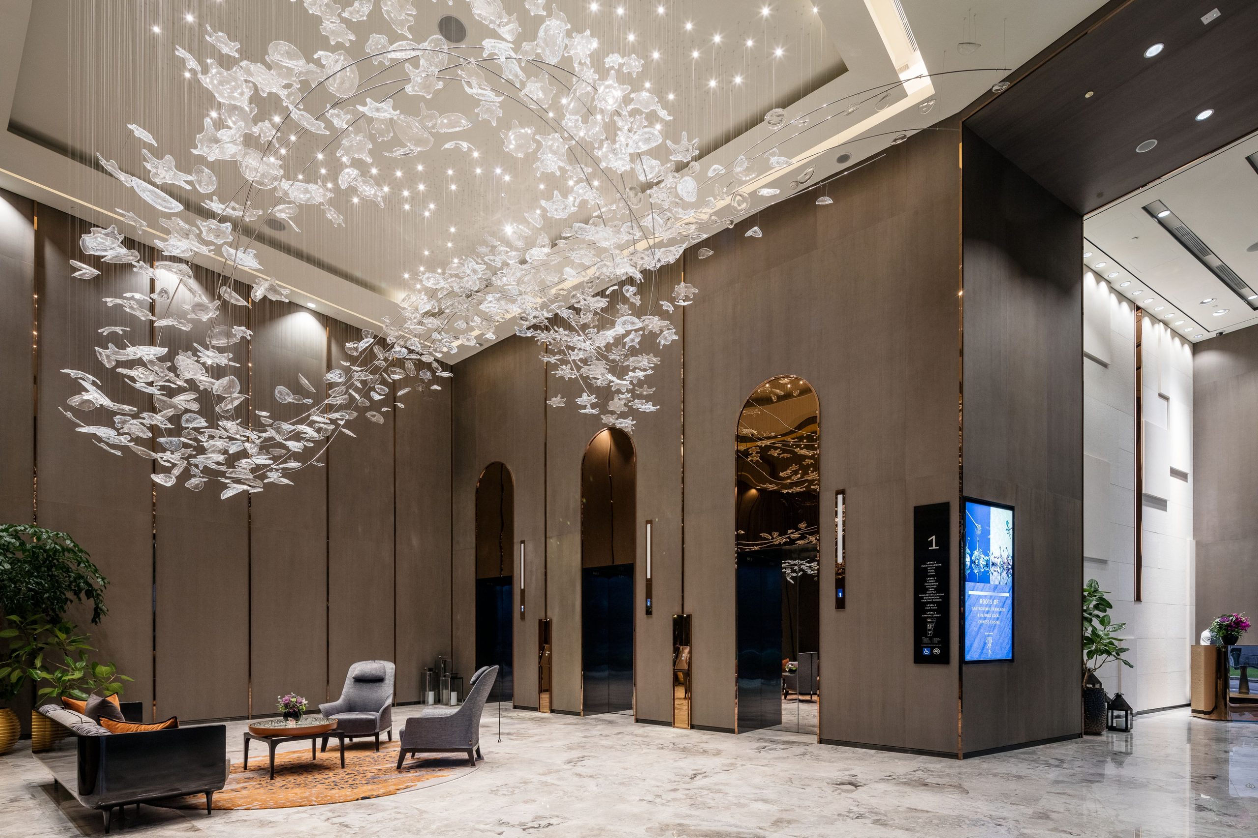 STELLAR chandelier seen against the lobby window wall