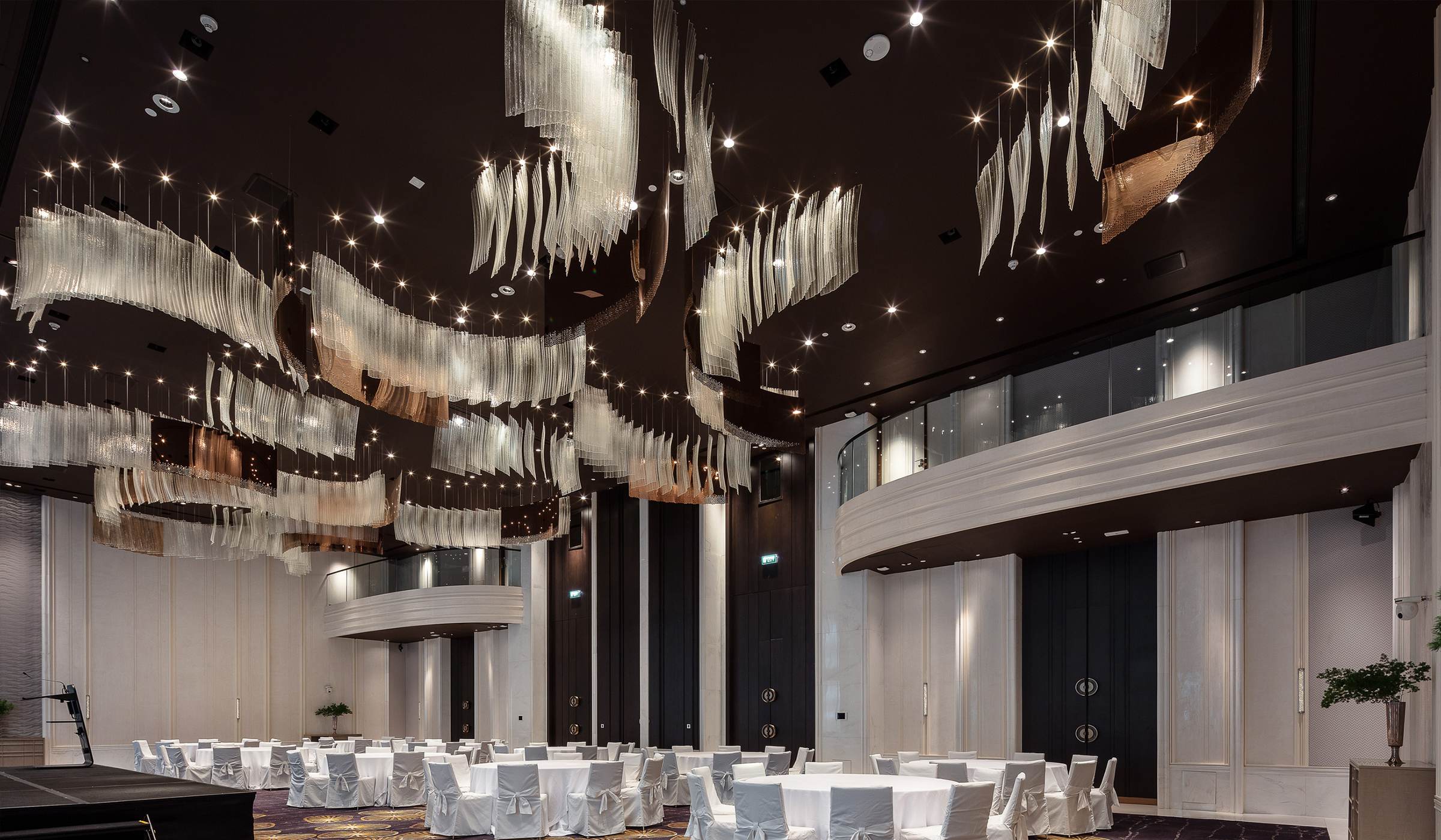 RIBBON glass banner chandelier by SHUCHUANG, banners across a dark ballroom ceiling