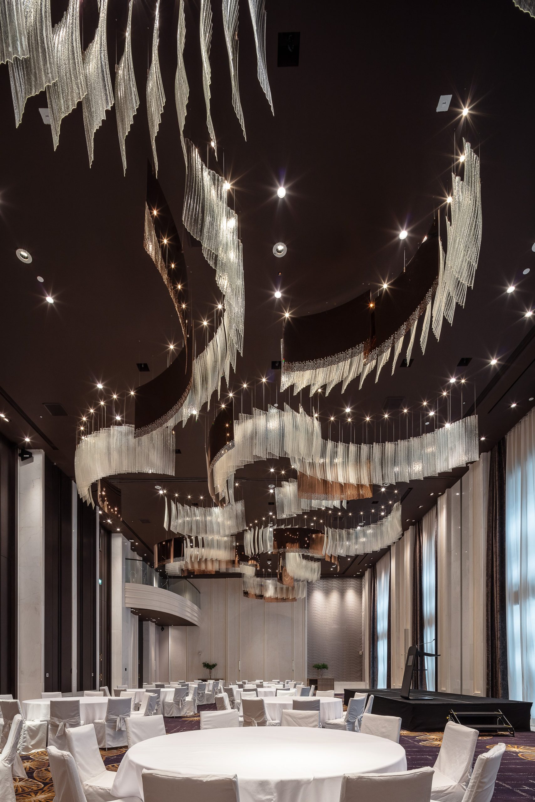 RIBBON banners curling and overlapping, seen from the ballroom floor