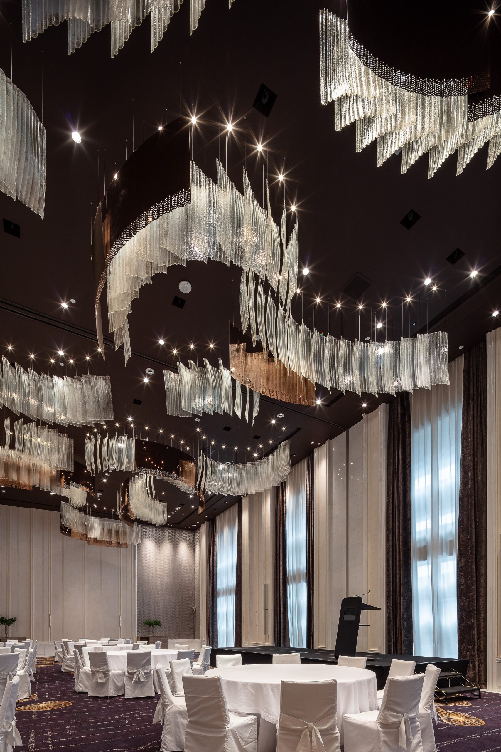 RIBBON chandelier seen down the length of the ballroom