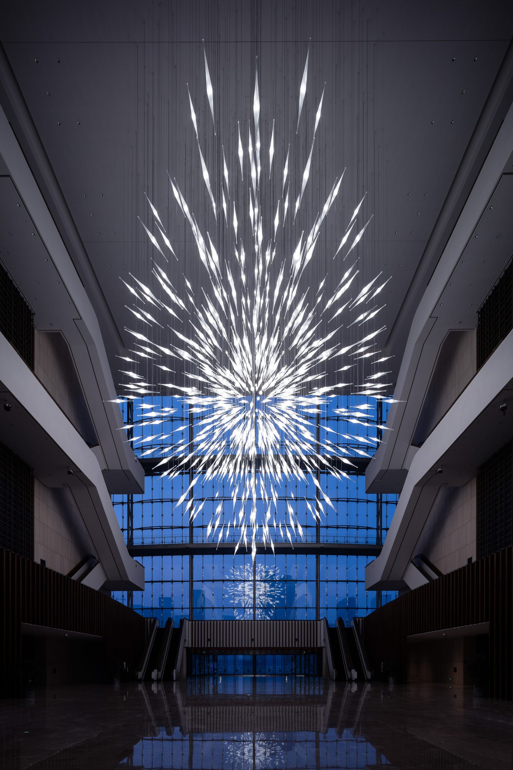 STARBURST chandelier seen from the atrium floor against the window wall