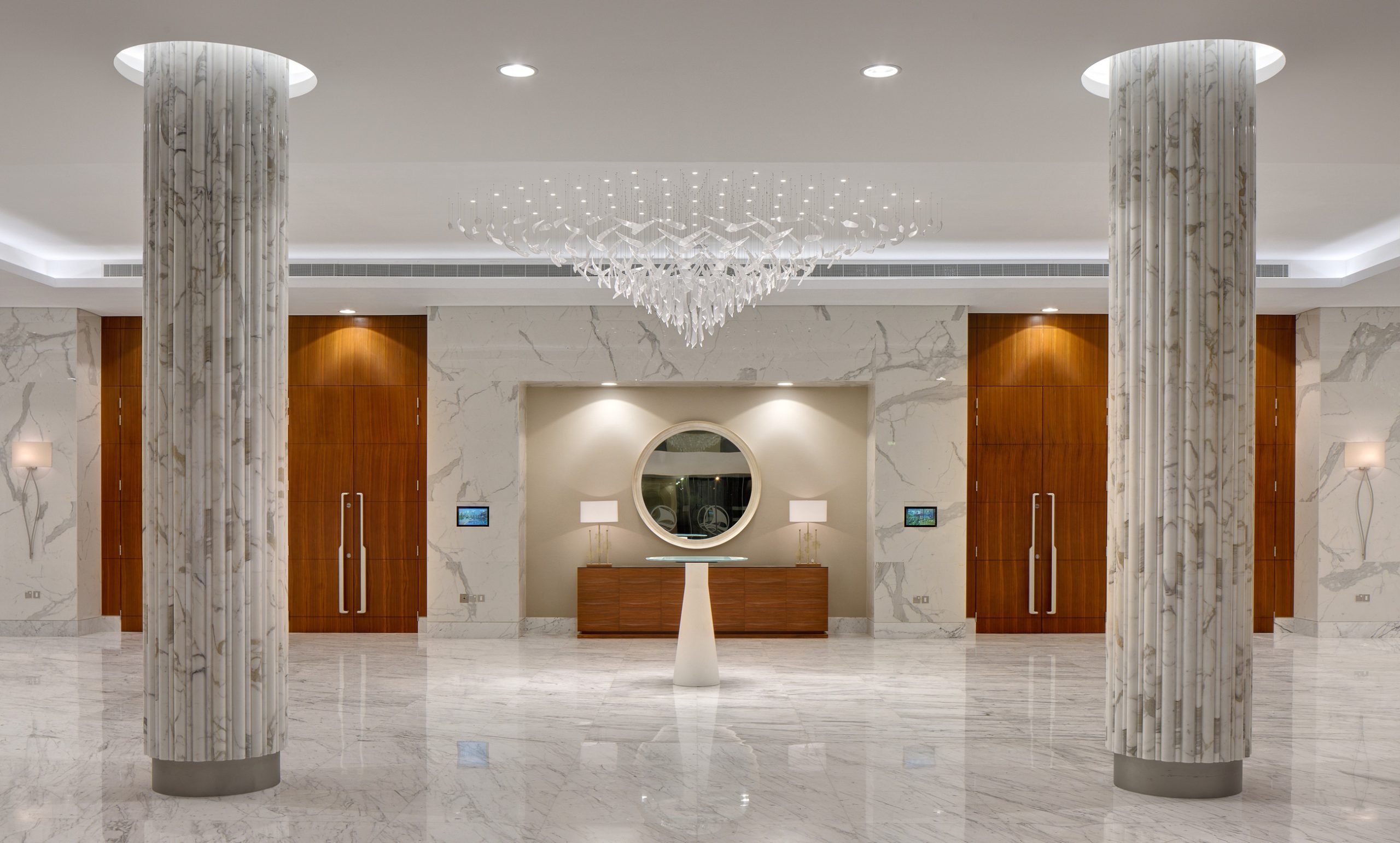 VALERIA chandelier seen against the marble lobby wall