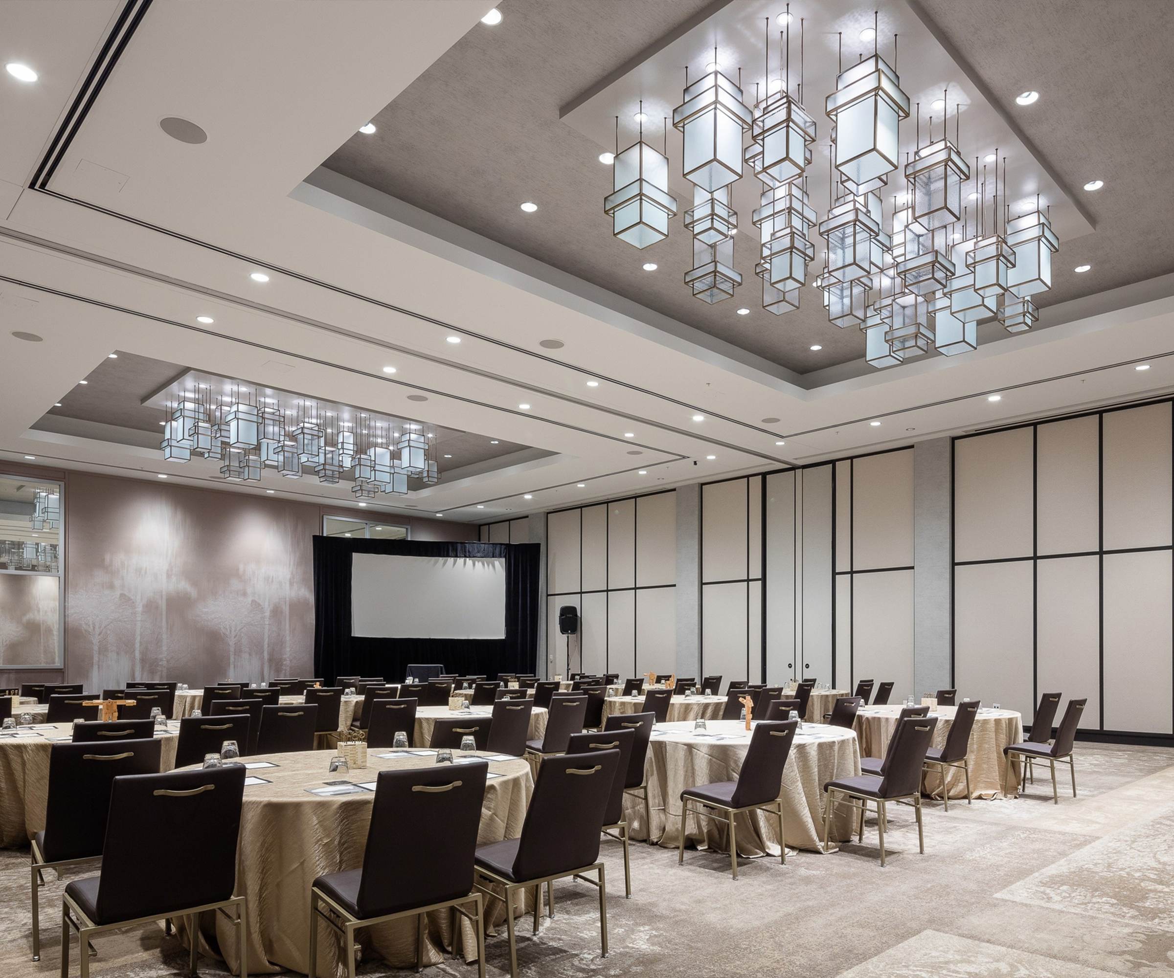 BRASS lantern chandelier by SHUCHUANG, boxes at staggered heights over a meeting room