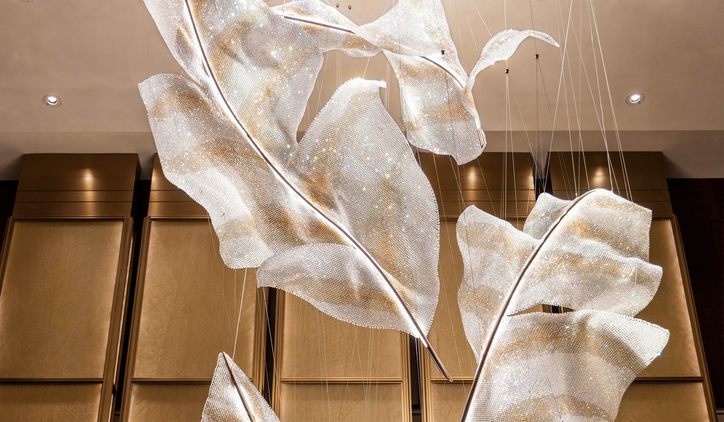 ARIA chandelier, curved crystal mesh forms at staggered heights