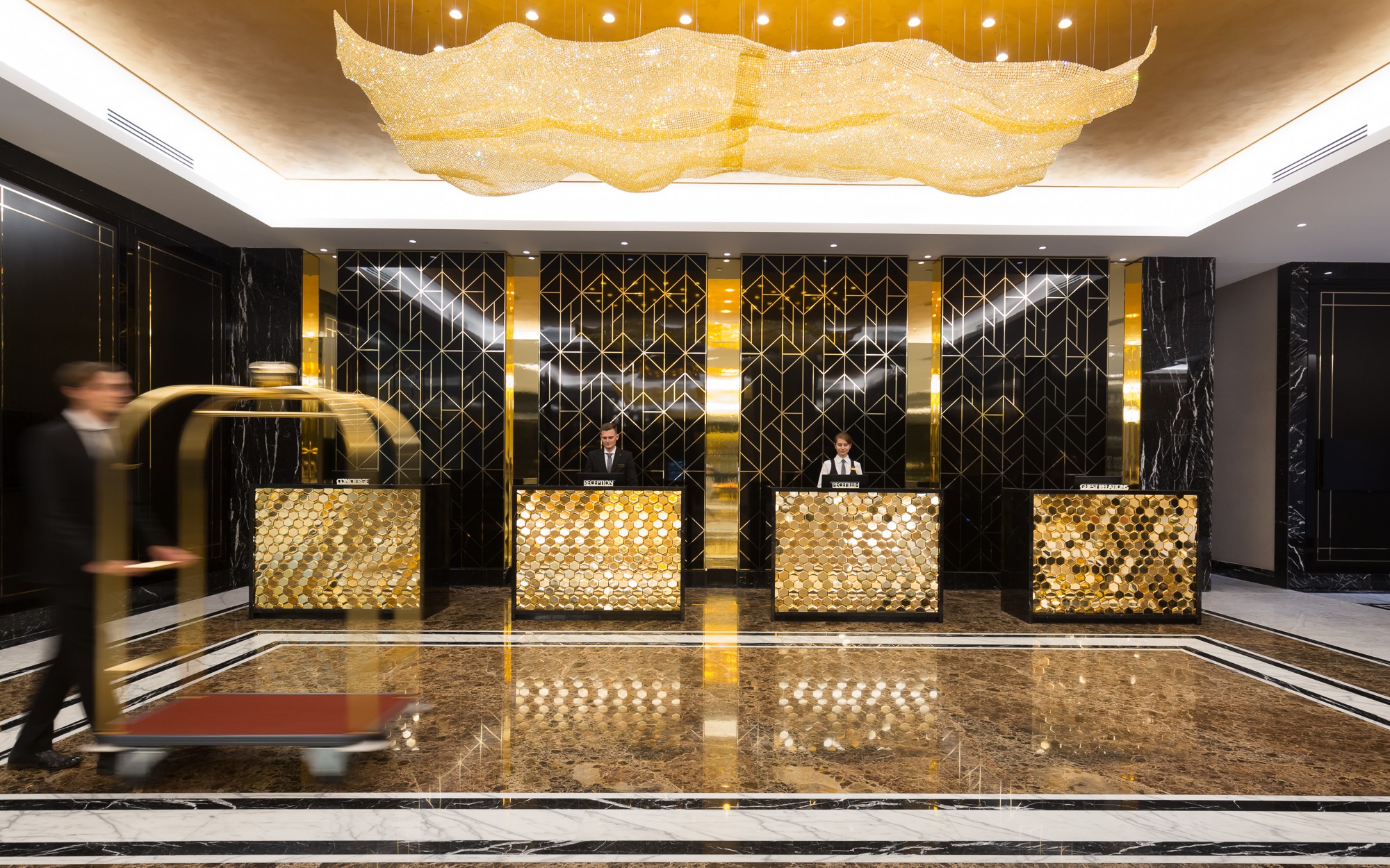 AURORA gold crystal ceiling light with the reception desk in use