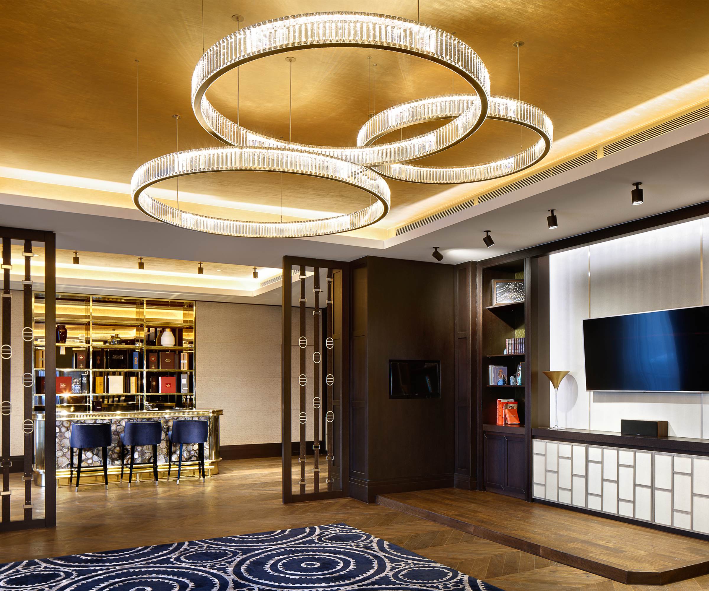 ORBIT crystal ring chandelier by SHUCHUANG, rings crossing beneath a gold ceiling