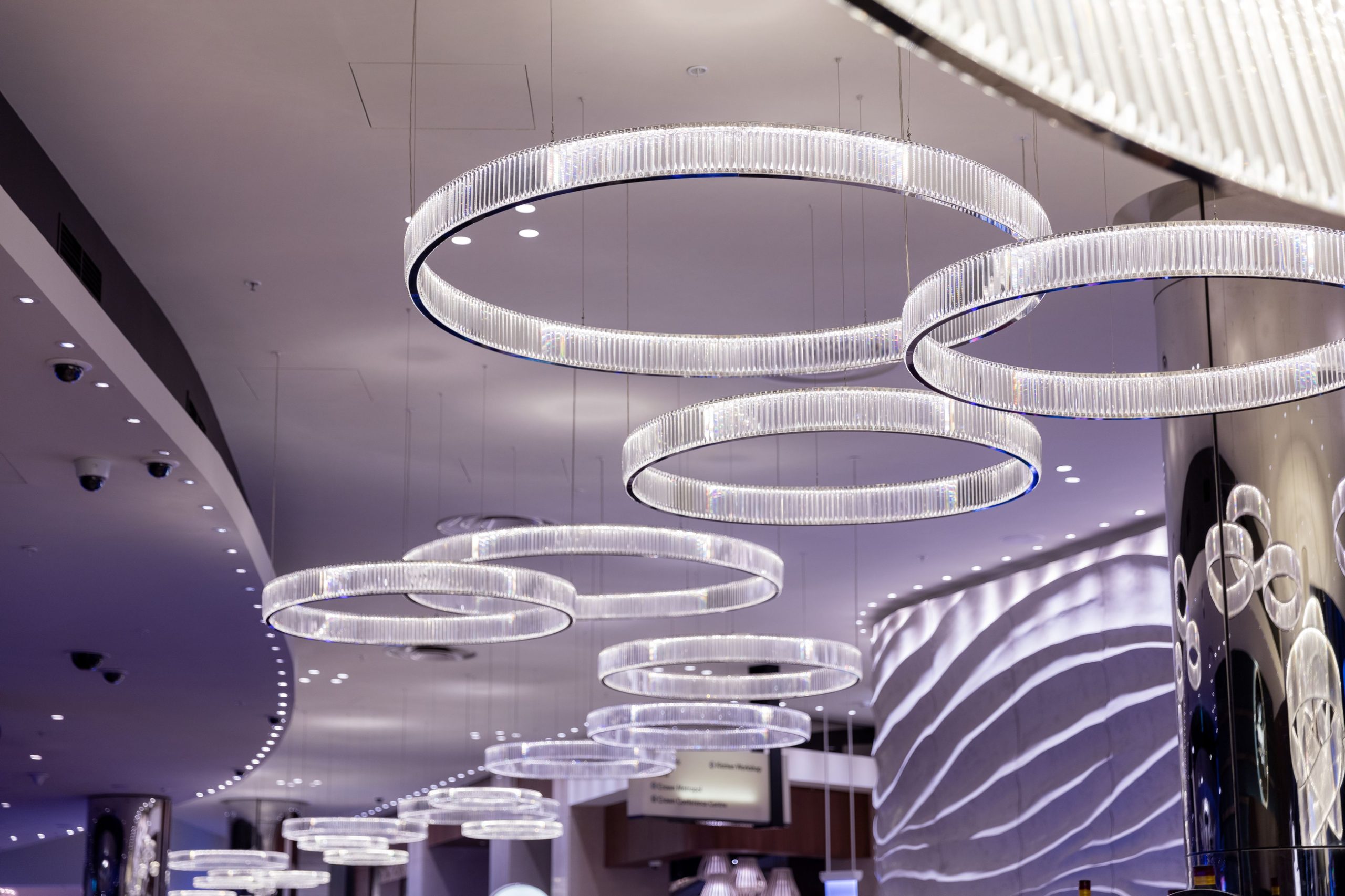 CORINTH drum chandeliers run singly down a long hall