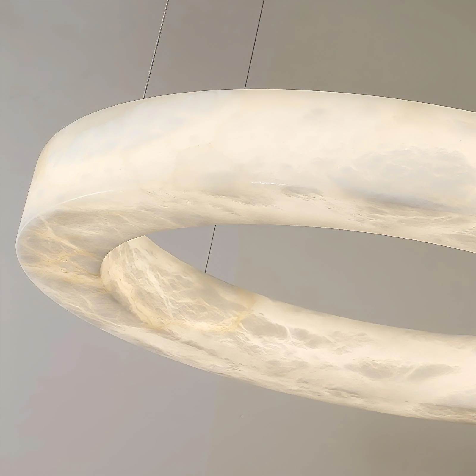 HELIOS alabaster pendant light hanging over a dining table