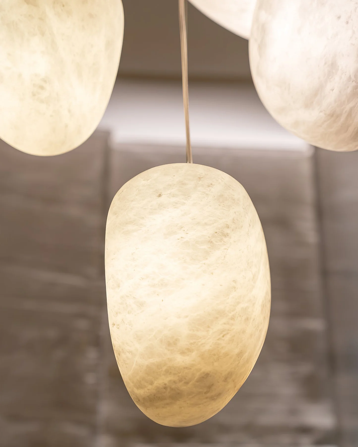 DUNE alabaster pendant light hanging over a dining table