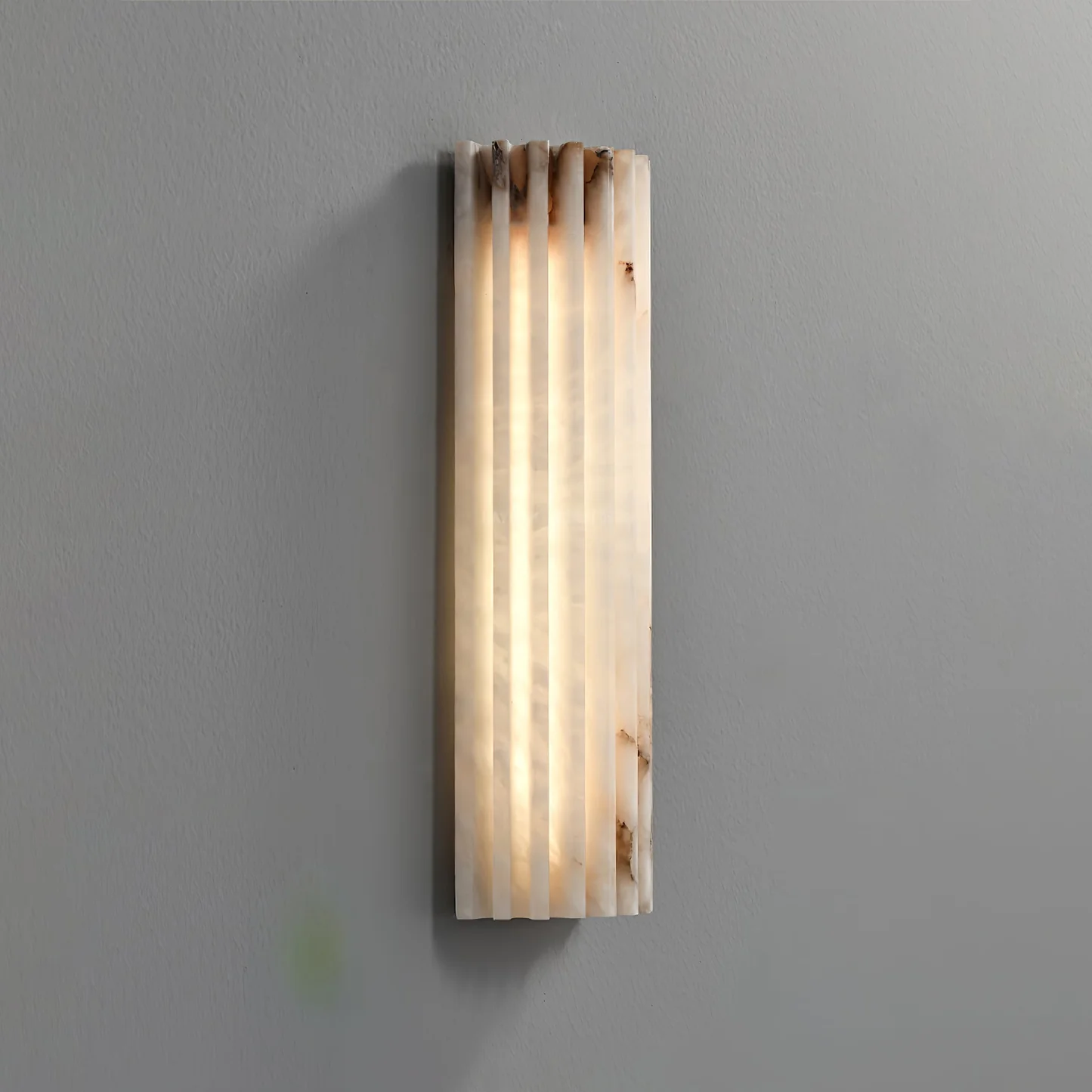 FLORA alabaster pendant light lit in a living room