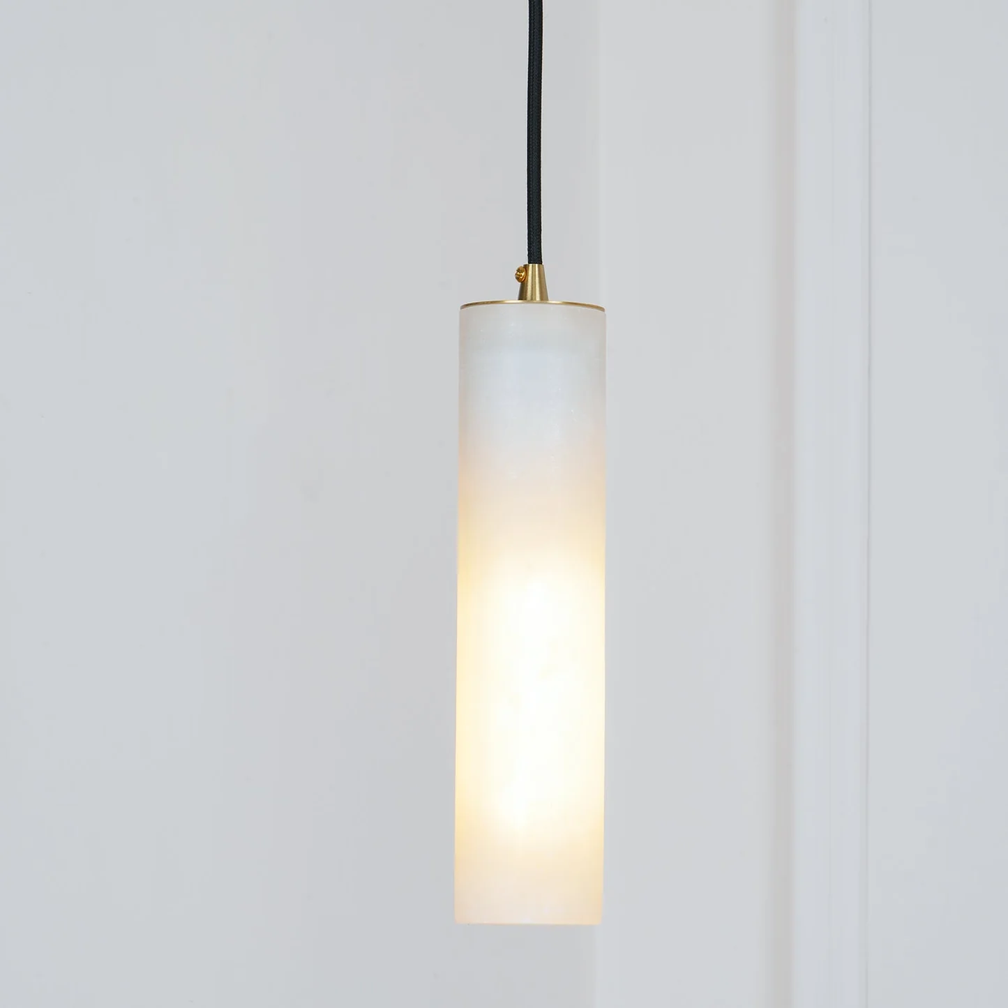 MILAN alabaster pendant light lit in a living room