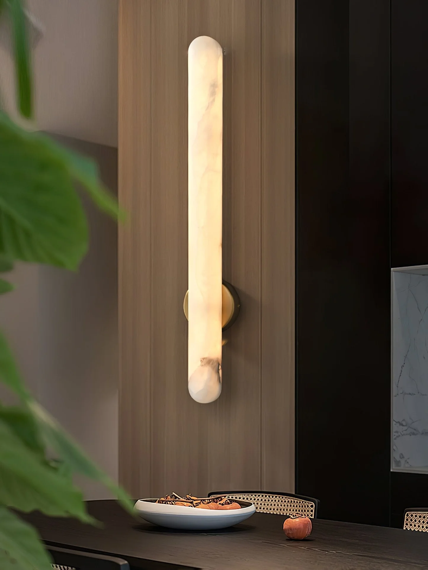 ELARA alabaster Wall sconce lit in a living room